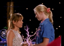 a couple of girls standing next to each other with a lightning bolt coming out of their hands