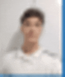 a blurry picture of a man wearing a white shirt .