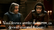 two men sitting at a table with the words " vous deviez arreter de sourire " on the bottom