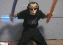 a young boy wearing headphones and sunglasses is holding two swords