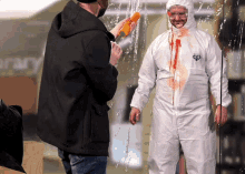 a man in a white coverall is standing in front of a glass wall with the word library on it