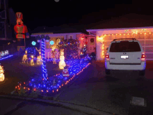 a white ford suv is parked in front of a house with christmas lights