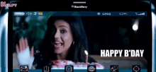 a blackberry phone screen shows a woman holding a cake with a candle and the words happy b day .