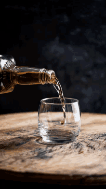 a bottle of whiskey is poured into a glass