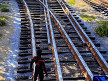 a man in a spider suit stands on a train track