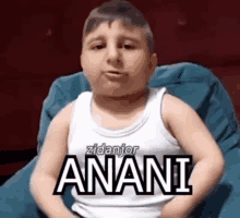 a young boy is wearing a white tank top that says anani