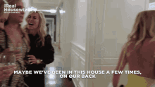 a group of women are walking down a hallway with the words maybe we 've been in this house a few times