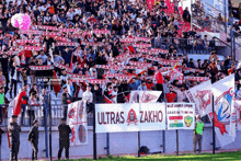 a crowd of people in a stadium holding a banner that says ultras zakho