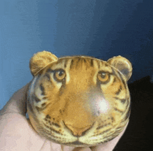 a person is holding a tiger shaped object in their hand