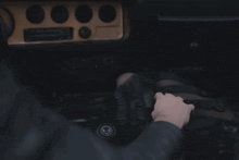 a person 's hand is on the steering wheel in a car