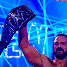 a man is holding up a wrestling championship belt in front of a blue background that says ' the next big thing '