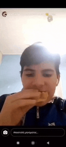 a young man is taking a selfie while eating a hot dog .