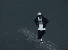 a man is playing hopscotch on the sidewalk