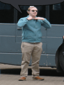 a man wearing sunglasses and a blue jacket is standing in front of a blue van