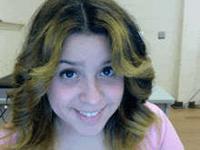 a close up of a woman 's face with a pink shirt