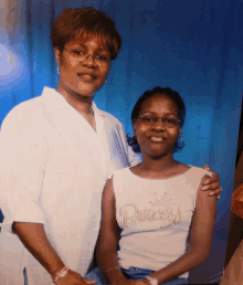 a woman and a girl posing for a picture with the girl wearing a princess shirt