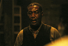 a man in a dark room is drinking from a bottle
