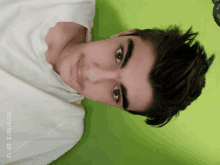 a young man laying on his back with a green background and a photo taken on december 22 2012