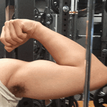 a man flexes his arm in front of a rack that says 10 on it