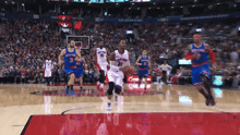 a toronto raptors player dribbles the ball during a game