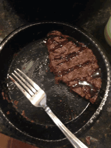 a steak on a paper plate with a fork in it