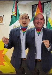 a man with glasses and a rainbow scarf is standing next to another man with a rainbow scarf