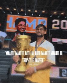 a man holding a trophy in front of a sign that says 20