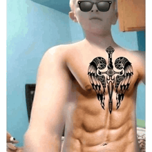 a man with a tattoo of a sword with wings on his chest