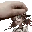 a hand is holding a doll 's head with a hat on .
