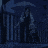 a man holding an umbrella is standing next to a woman sitting on the ground