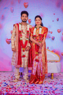 a bride and groom are posing for a picture with hearts behind them