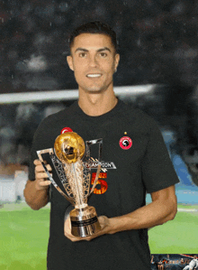 a man wearing a black shirt that says champions holds a trophy