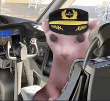 a pink cat wearing a pilot hat sits in the cockpit of a plane