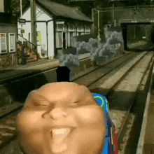 thomas the tank engine is making a funny face while sitting on a train .