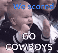 a baby is being held by a woman with the words we scored go cowboys on it