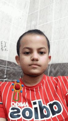 a young boy wearing a red striped shirt that says coibp