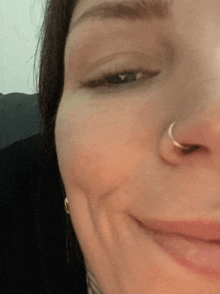 a close up of a woman 's face with a nose ring .