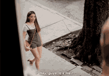 a woman walking down a sidewalk with the words hey guys it 's me