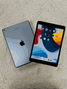 an apple ipad sits on a carpet next to its back