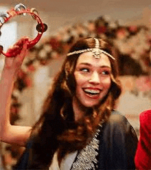 a woman is holding a tambourine in her hand .