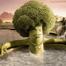 a broccoli with a face and a necklace is sitting in a bathtub .