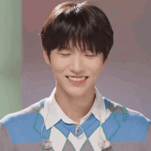 a close up of a young man smiling with his eyes closed and wearing headphones .