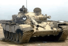 a large military tank is parked in the middle of a desert .