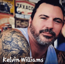 a man with a tattoo on his arm and the name kelvin williams