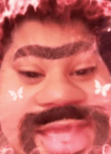 a close up of a person 's face with a mustache and a flower crown on their head .