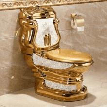 a gold toilet sits in a bathroom next to a toilet paper holder