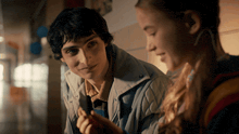 a boy and a girl are looking at each other