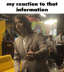 a man in a suit giving a thumbs up with the words my reaction to that information above him