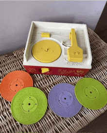 a fisher price record player with four colorful records