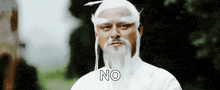 a man with a beard and white hair is wearing a white robe and a white hat .